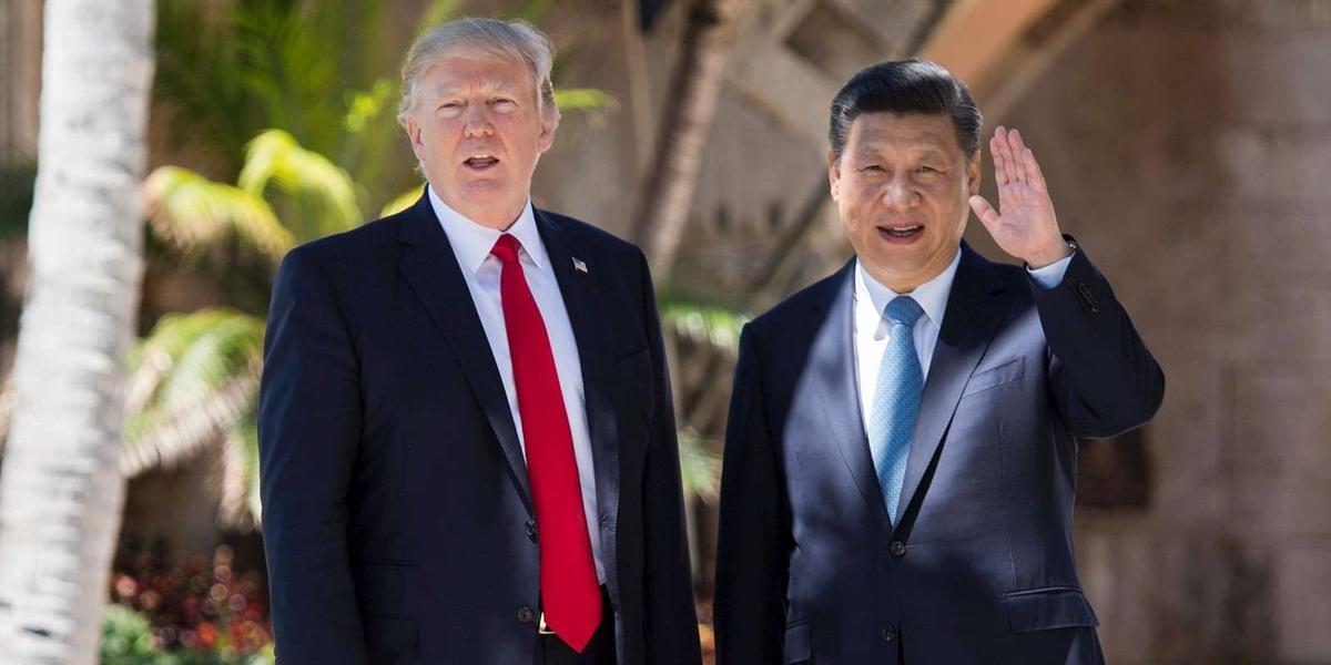 TOPSHOT - Chinese President Xi Jinping (R) waves to the press as he w